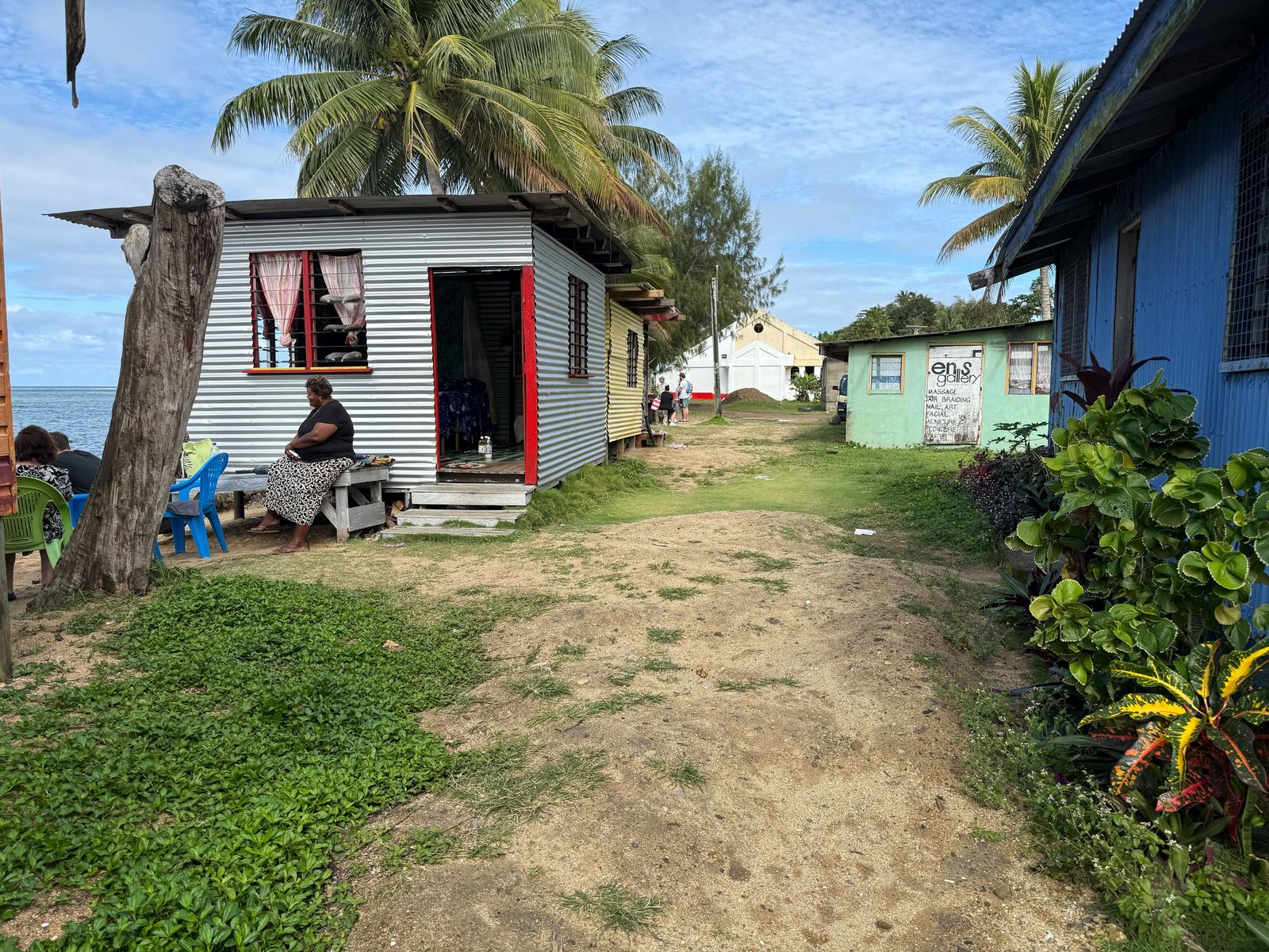 Living Hope Hut — village path with palm trees and ocean